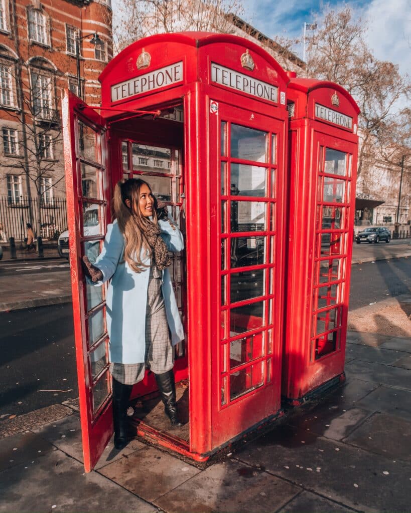 Lifestyle Instagram influencer @naohms, Naomi Genota, in a London telephone booth